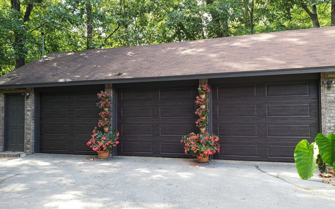 a row of garage doors with potted plants hanging from them