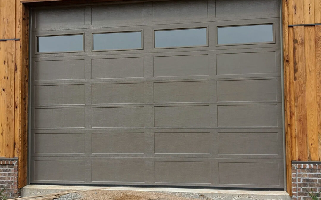 a gray garage door on a wooden house