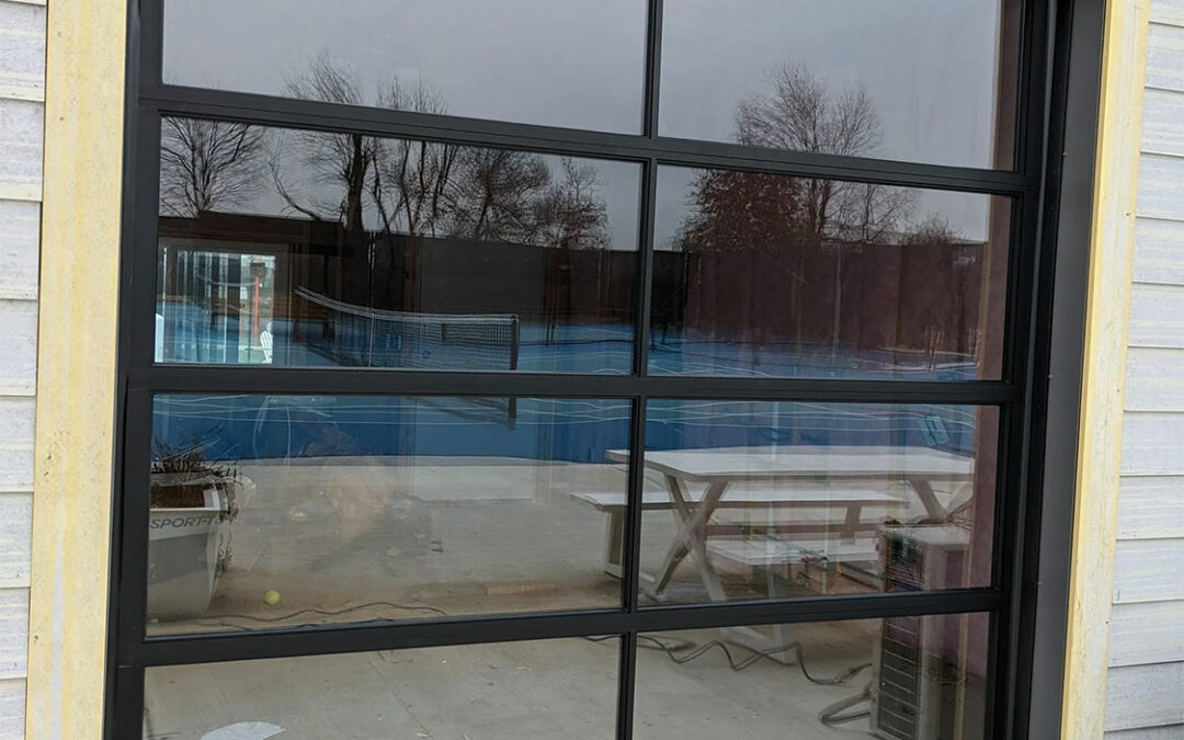 a tennis court is reflected in a garage door window