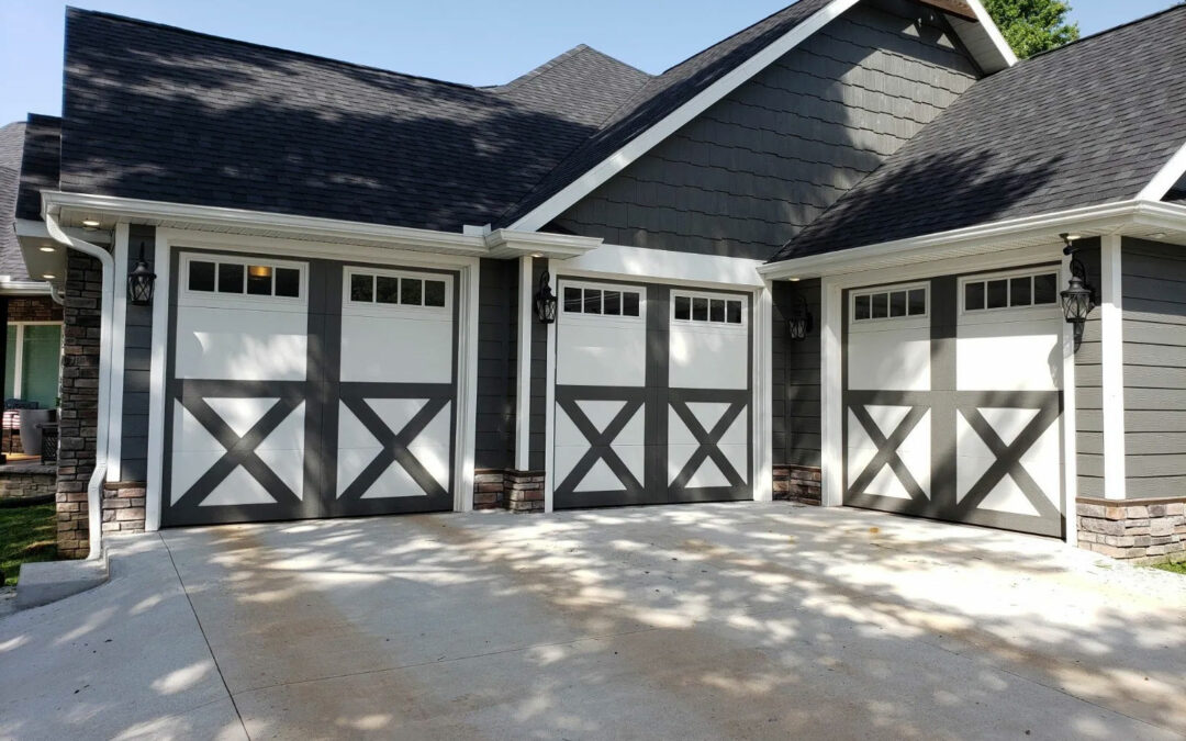 a gray and white house with three garage doors